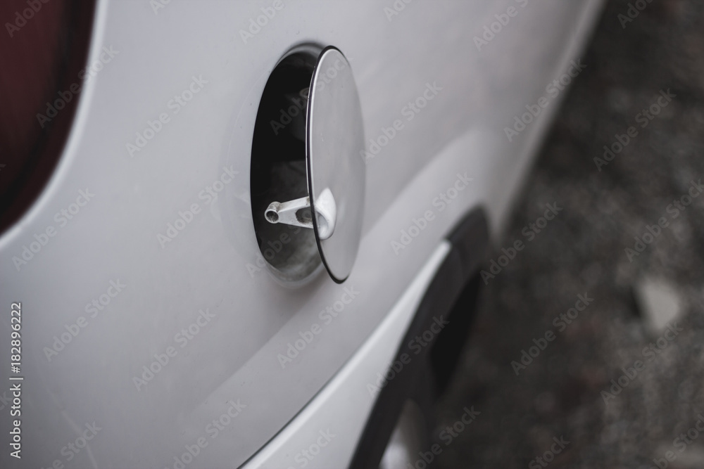 Close up to an open door of a car's fuel tank Close up to an open door of a car's fuel tank