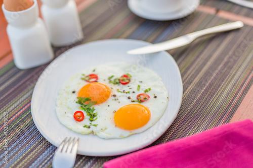 Fried eggs on wooden table, morning mood with breakfast and table setting