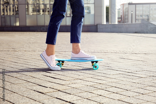 Hipster girl skateboarding outdoors