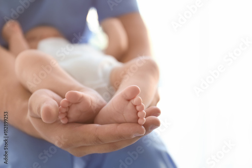 Male doctor holding baby at hospital photo