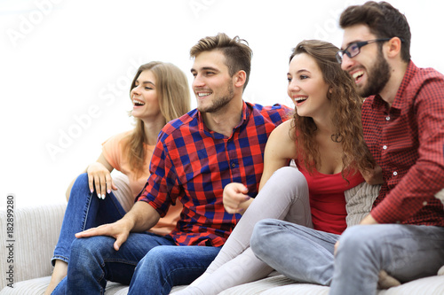 young friends sitting on the couch and rooting for their favorite team
