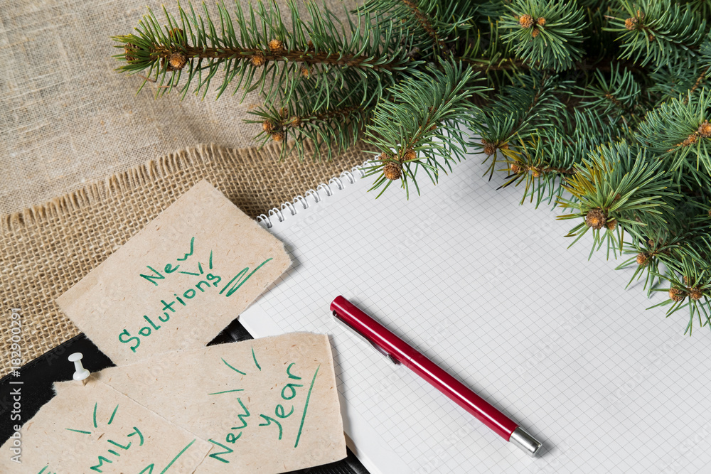 notes reminders and goals, a business notebook, on the next new year background with Christmas fir branches notes reminders and goals, a business notebook, on the next new year background with Christmas fir branches