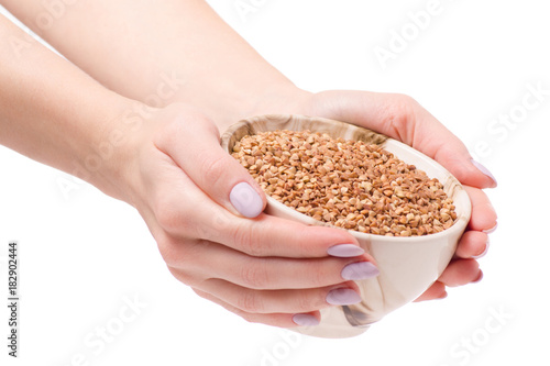 Buckwheat groats in a plate pial female hands