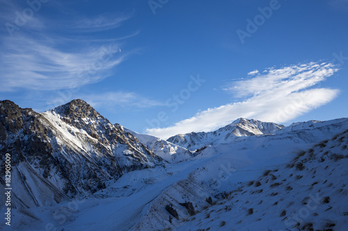 Зимний пейзаж. Красивые горы в снегу, белые облака на синем небе над живописным ущельем. Припрда Северного Кавказа © Ivan_Gatsenko