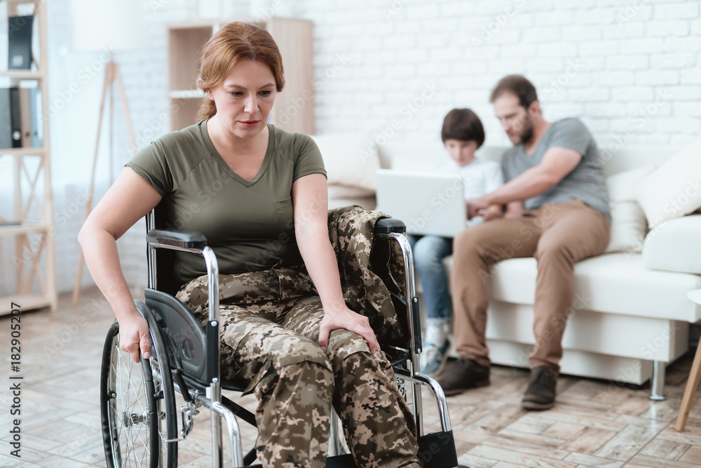 Woman veteran in wheelchair returned from army. A woman in a wheelchair is in pain. She's in military uniform. - obrazy, fototapety, plakaty 