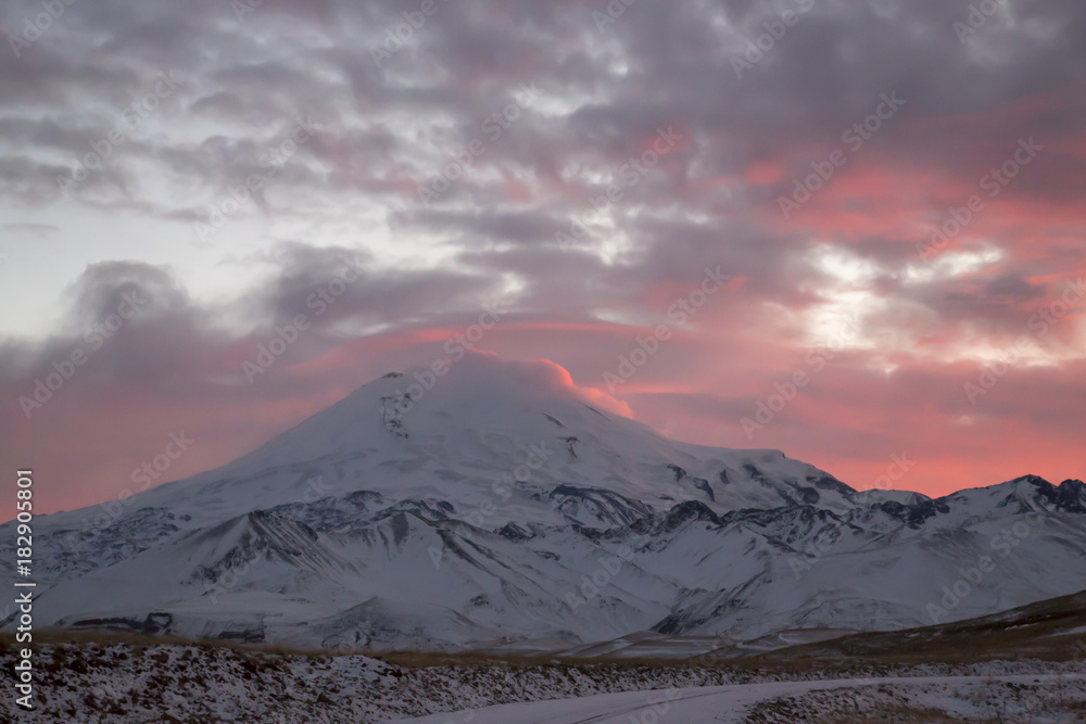 Зимний закат над снежными горами, красивые цвета на облачном небе, заход солнца, природа Северного Кавказа