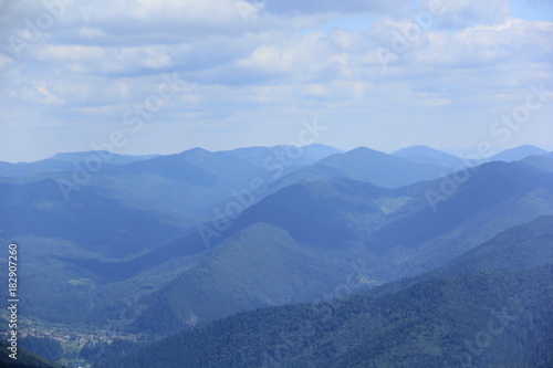 Blue blurred misty background of Carpathian mountains and Bukovel ski resort in summer