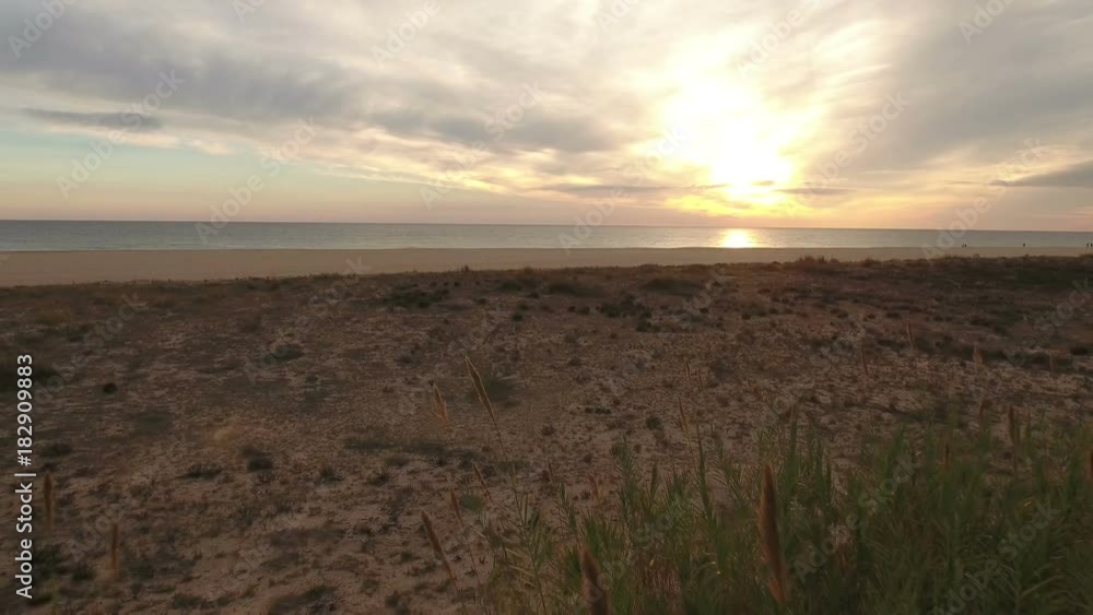 Aerial. Video in motion through the beach, sunset at the sea. Aerial. Video in motion through the beach, sunset at the sea.