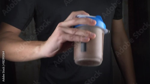 Slow motion. 4k. Young man making a protein shake at home. anonymously photo
