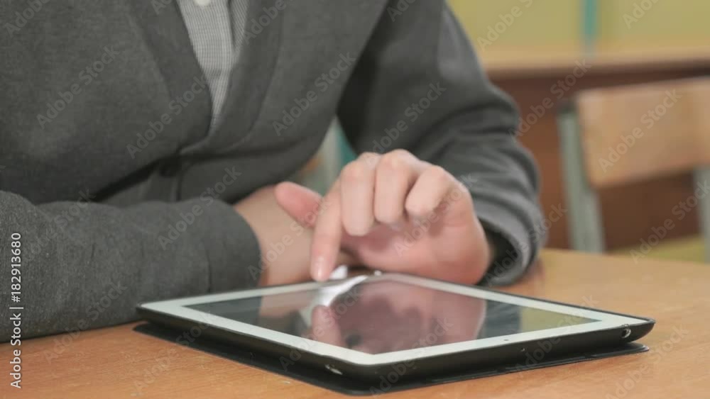 Close-up of hand of man dressed in grey sweater sits at desk at office the resting and looking at favorite photos using the screen of computer tablet in white-black colour. Close-up of hand of man dressed in grey sweater sits at desk at office the resting and looking at favorite photos using the screen of computer tablet in white-black colour.