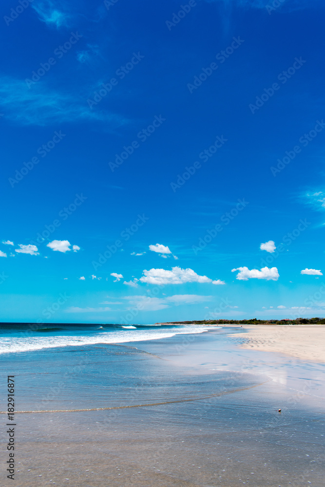 waves break on a sunny blue beach