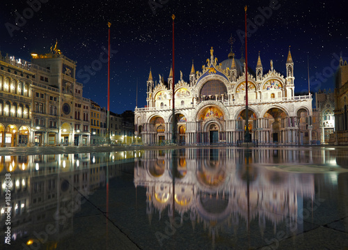 Basilica in San Marco square in Venice with reflection on high tide night