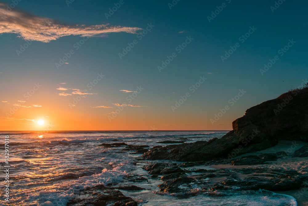 sun setting over a rocky beach