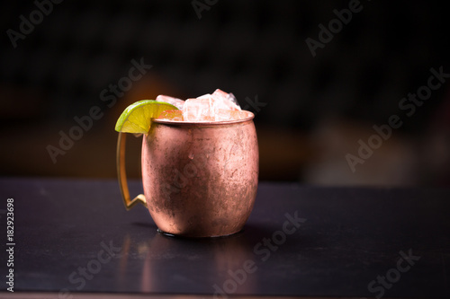 Isolated Moscow mule cocktail overflowing with ice in a copper mug