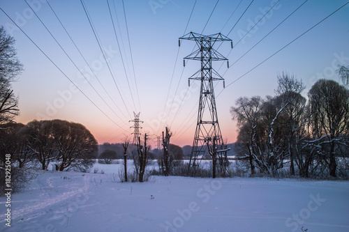 High-voltage pole in the winter at sunset