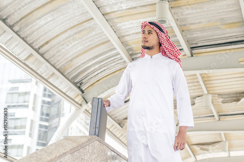 arab businessman looking on copy space while standing, young professional employee waiting for international partners outdoors near big company.portrait
