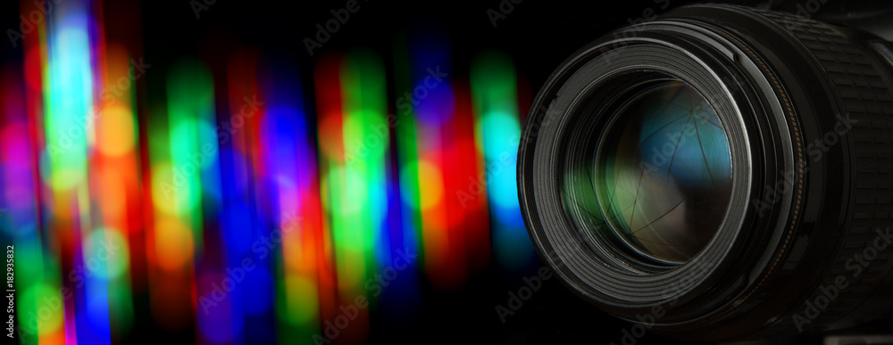 Photo lens and black background with individual light blur