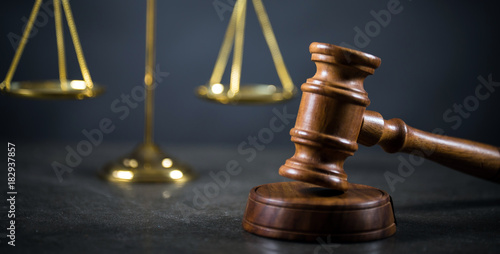 Golden scales of justice, gavel and books on brown background, Law code