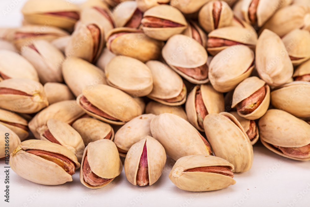 Close Up Group Of Dry, Fresh And Large Raw Pistachio Nuts In Shell Isolated On White Background, Selective Focus