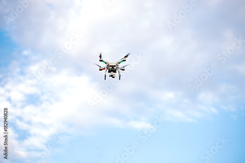 Quadcopter drone with the camera against the blue sky