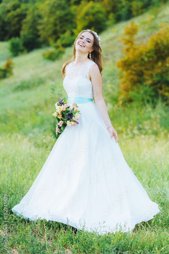 bride posing for the photographer on the nature