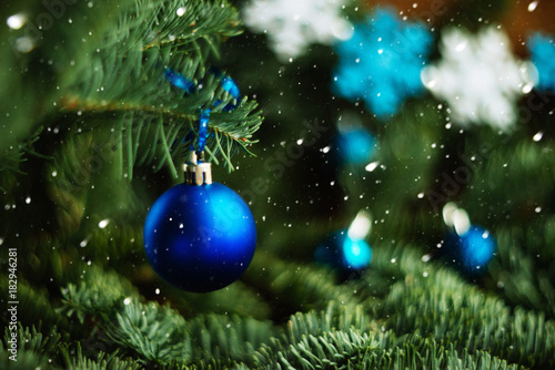 Forest Christmas tree branch with blue ornament. New year greeting background. Copy space.