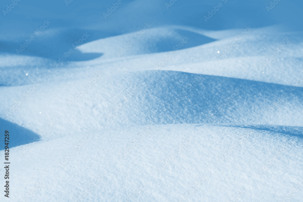 Winter background of snowdrifts in the sunlight