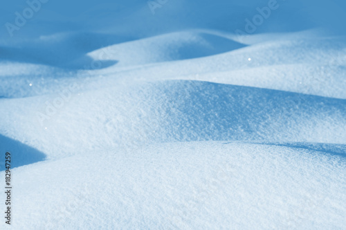 Winter background of snowdrifts in the sunlight