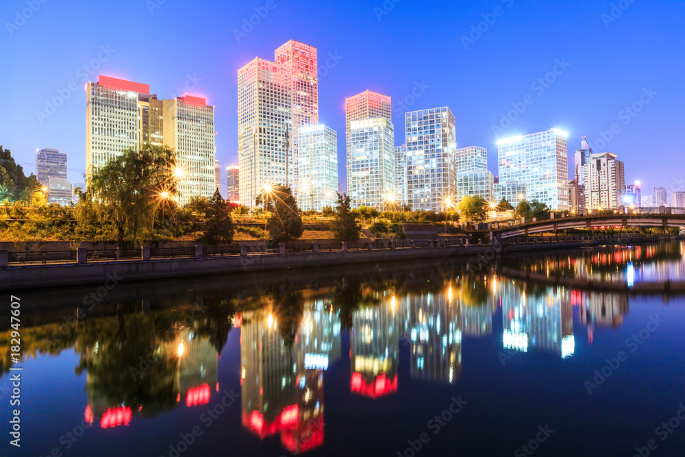 Fototapeta premium Business district office buildings and water reflection in Beijing at night
