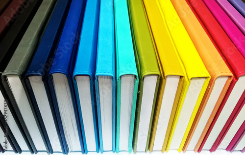 Books. A lot of books with bright covers in one pile isolated on white background. Design element, paper and leather texture. Colorful books on the shelf, close up