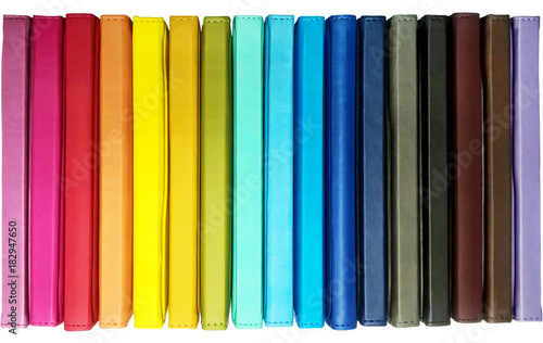 Books. A lot of books with bright covers in one pile isolated on white background. Design element, paper and leather texture. Colorful books on the shelf, close up