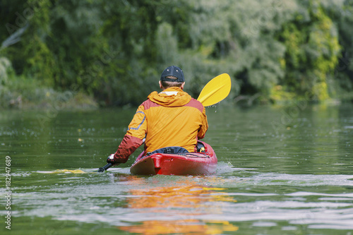 Fototapeta Naklejka Na Ścianę i Meble -  Canoeing. A man is rowing along the river.