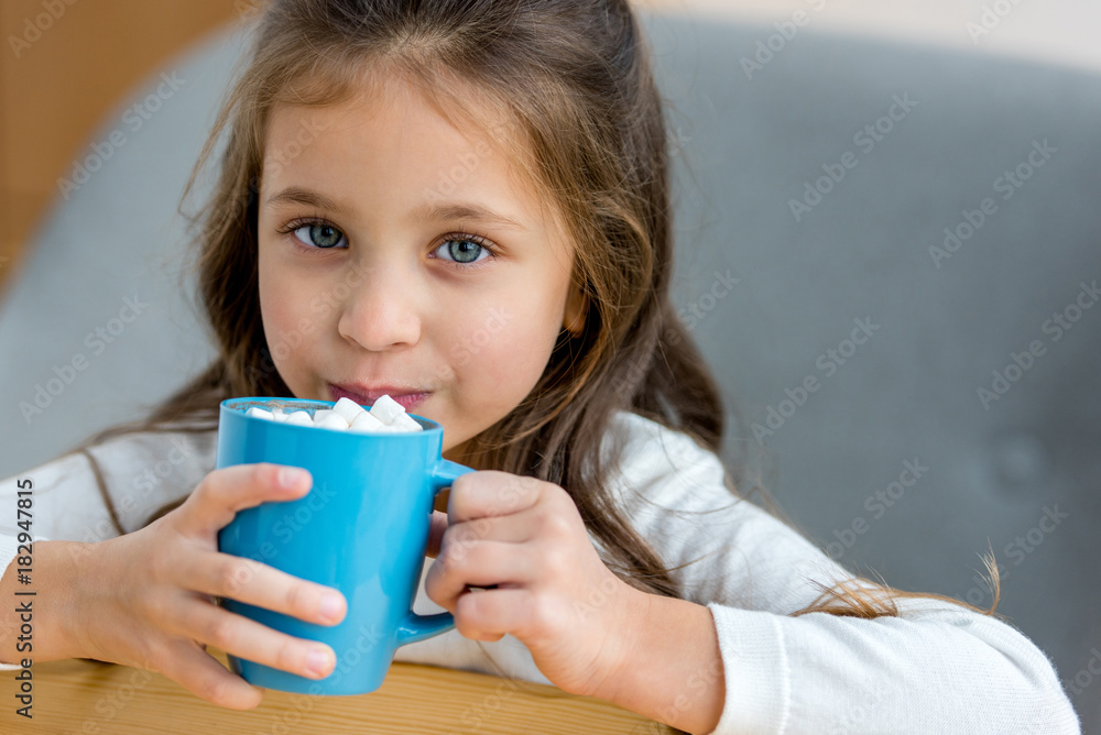 adorable kid drinking cacao with marshmallow in cafe adorable kid drinking cacao with marshmallow in cafe