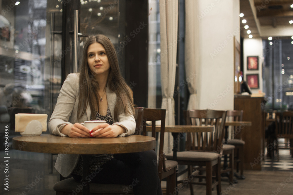 the girl sits in a cafe