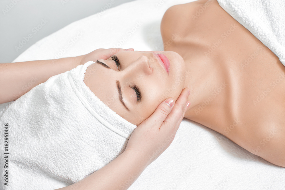 woman receiving facial massage at spa salon
