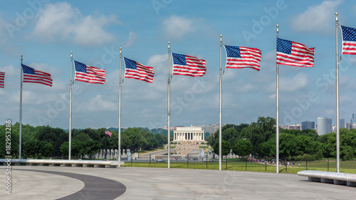 Washington DC skyline with Abraham Lincoln memorial and American flags.