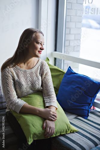 Wallpaper Mural Young woman sitting on striped sofa and looking out the window. Torontodigital.ca
