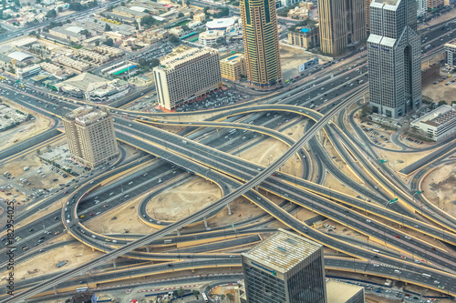 Photography Aerial view of traffic on Sheikh Zayed Road highway interchange in Dubai downtown from top of Burj Khalifa, United Arab Emirates