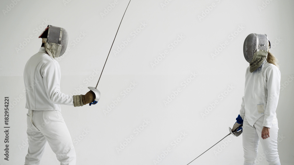 Two fencers have fencing training on white background