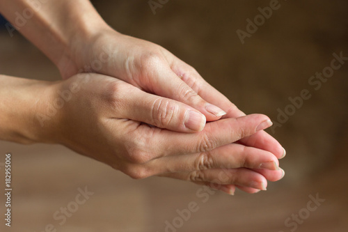 Hands are connected close-up. A gesture of help, supplication, repentance.