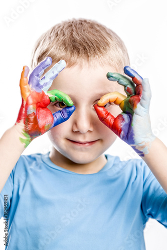 portrait of a 4 year old caucasian boy with unevenly colored hands with acrylic paints. concept of creativity  fun and carefree.