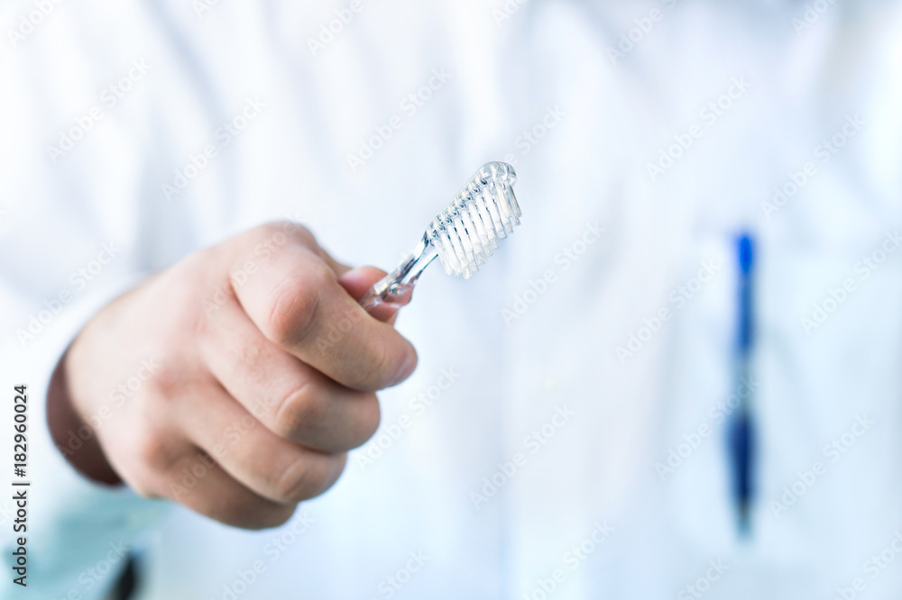 Dentist holding toothbrush. Dental hygienist with a tooth brush. Oral hygiene concept. Dentist holding toothbrush. Dental hygienist with a tooth brush. Oral hygiene concept.