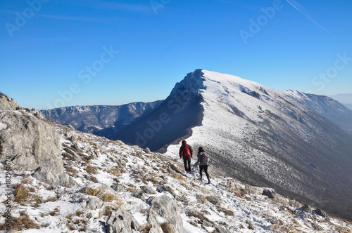 Couple of mountaineers hiking on snowy mountain into the sun. Climbers high in snowy mountains