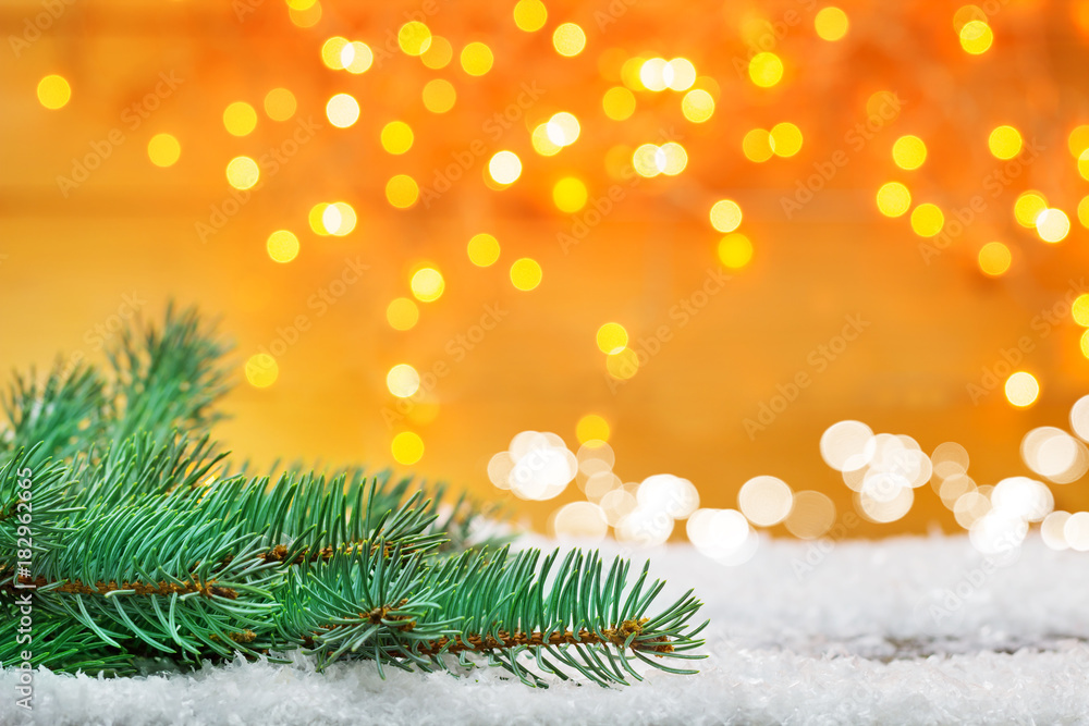 Weihnachtshintergrund, Tanne im Schnee vor Bokeh, goldene Lichter