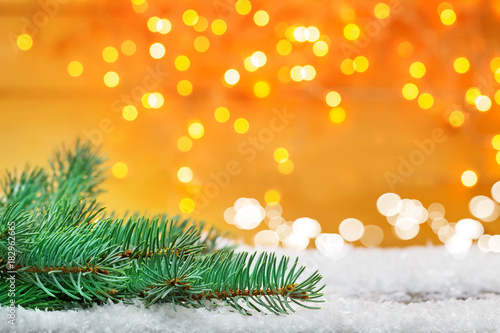 Weihnachtshintergrund  Tanne im Schnee vor Bokeh  goldene Lichter