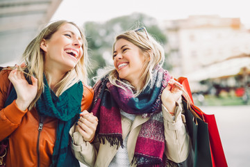 Happy friends shopping. Two beautiful young women enjoying shopping in the city.