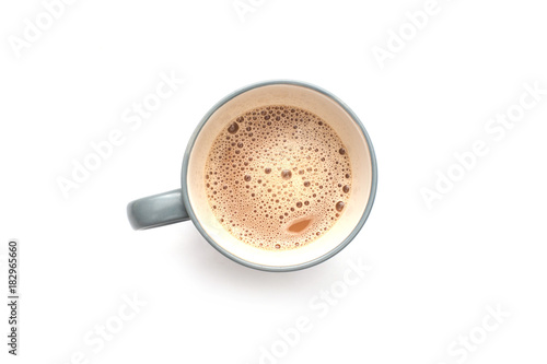 White coffee with milk in a mug view from top isolated over white background.