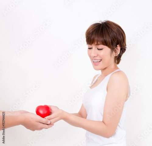 Man give the red heart to the young asia woman. Isolated on white background. Studio lighting. Concept for healthy.