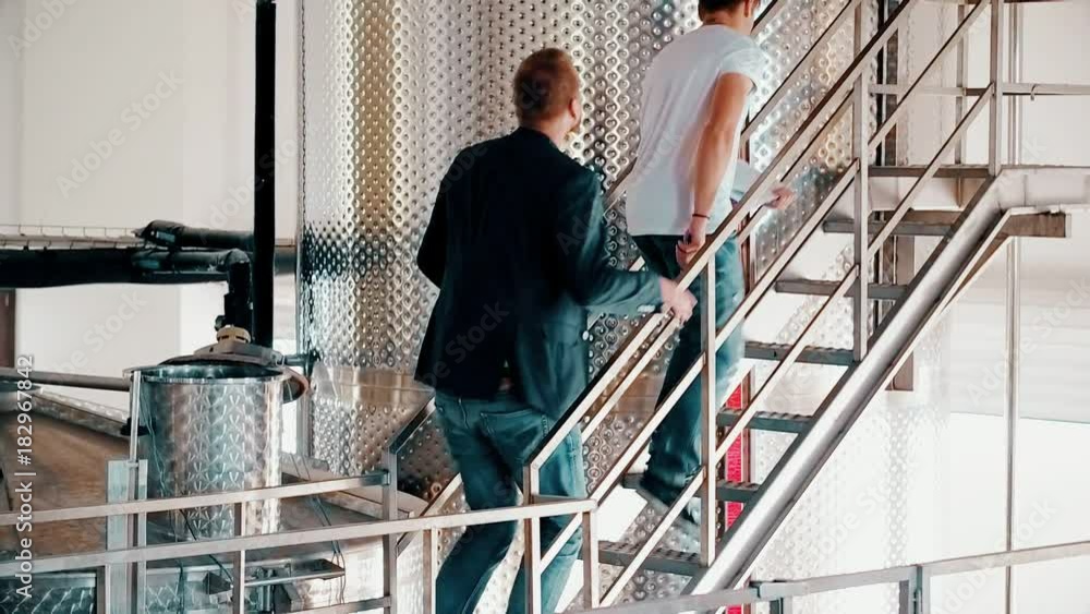 Business owner with engineer at wine factory controlling quality production Business owner with engineer at wine factory controlling quality production
