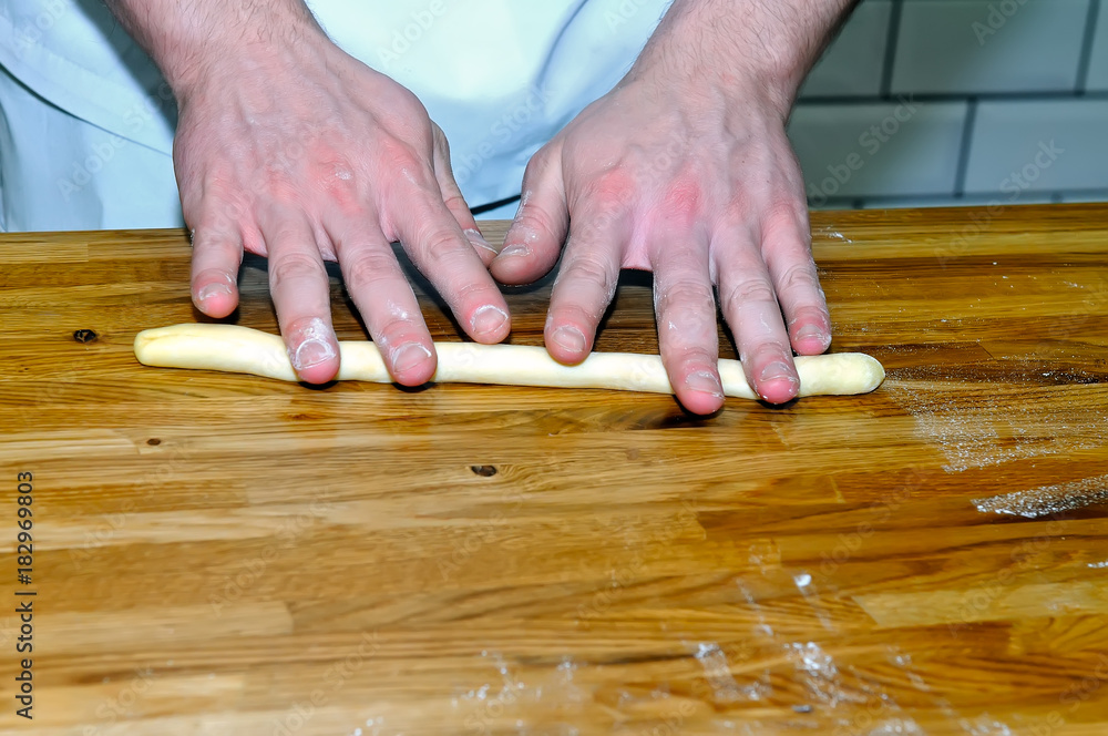 Men's hands on a wooden table rolled dough Men's hands on a wooden table rolled dough